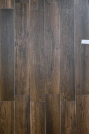 Wood look porcelain tile from Spain in dark brown color with some red hues for a warm style interior flooring.