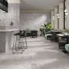 a lounge with 48x48 porcelain tiles that look like stone is gray color.